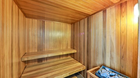 a sauna with wooden walls and a basket of rocks