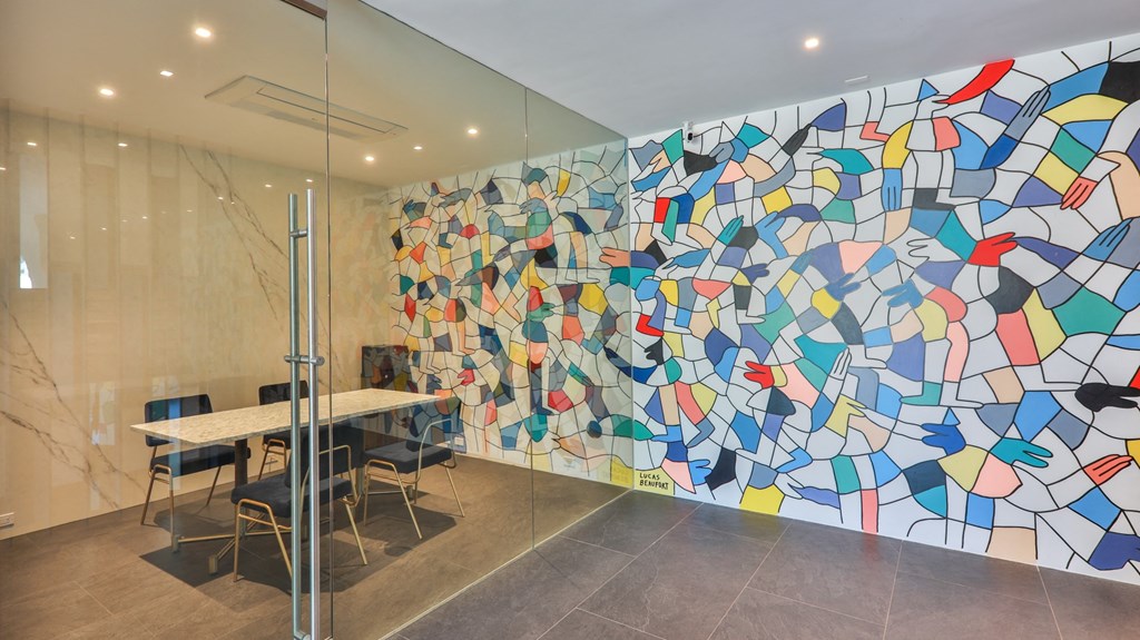 a colorful wall with a table and chairs in front of it