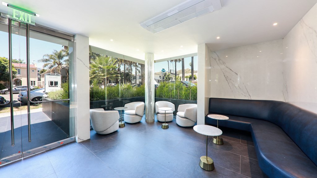 a living room with a couch and chairs and a large window