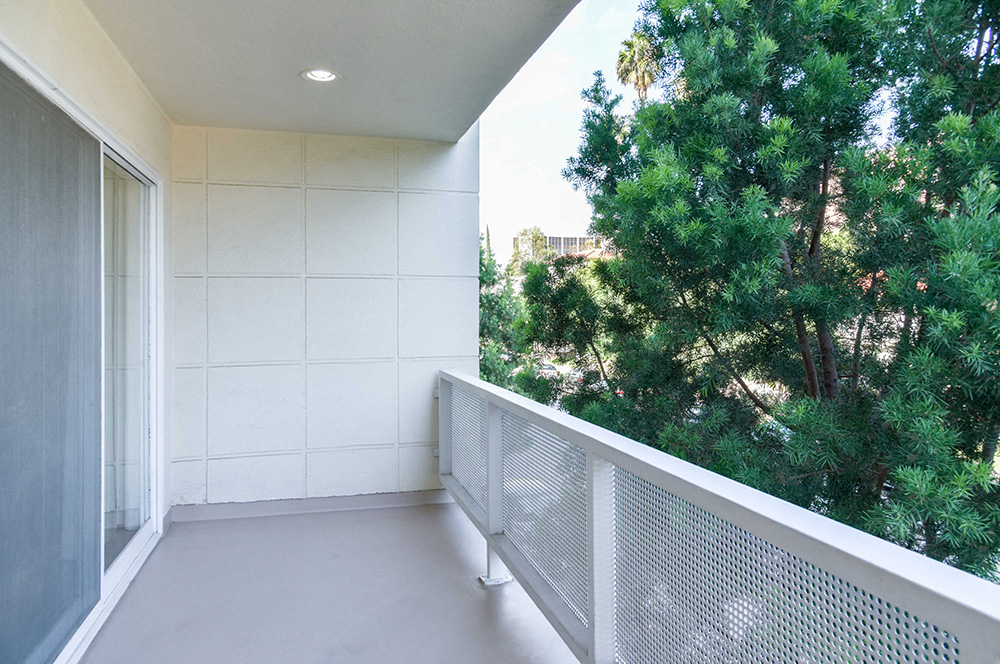 a large balcony with a view of a tree