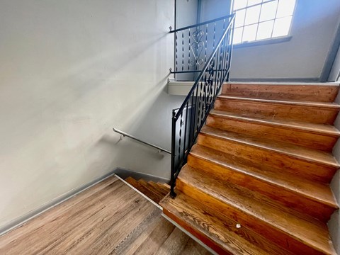 A wooden staircase with a metal railing.