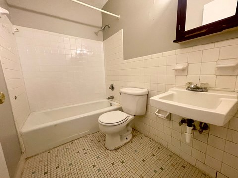A white toilet and sink in a tiled bathroom.