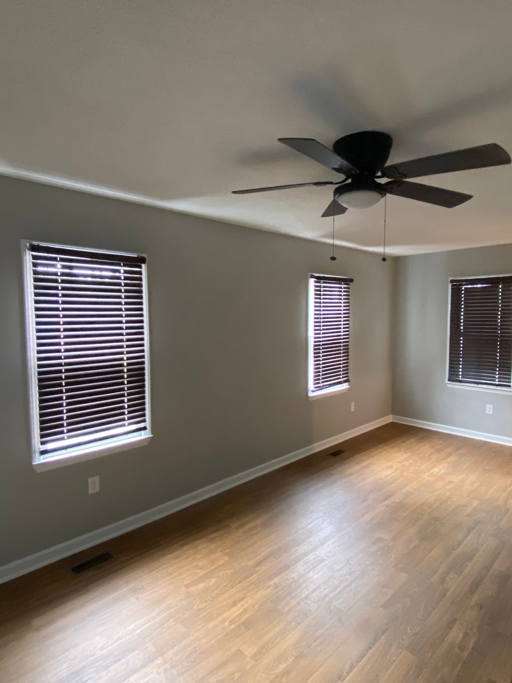 a living room with wood floors and a ceiling fan