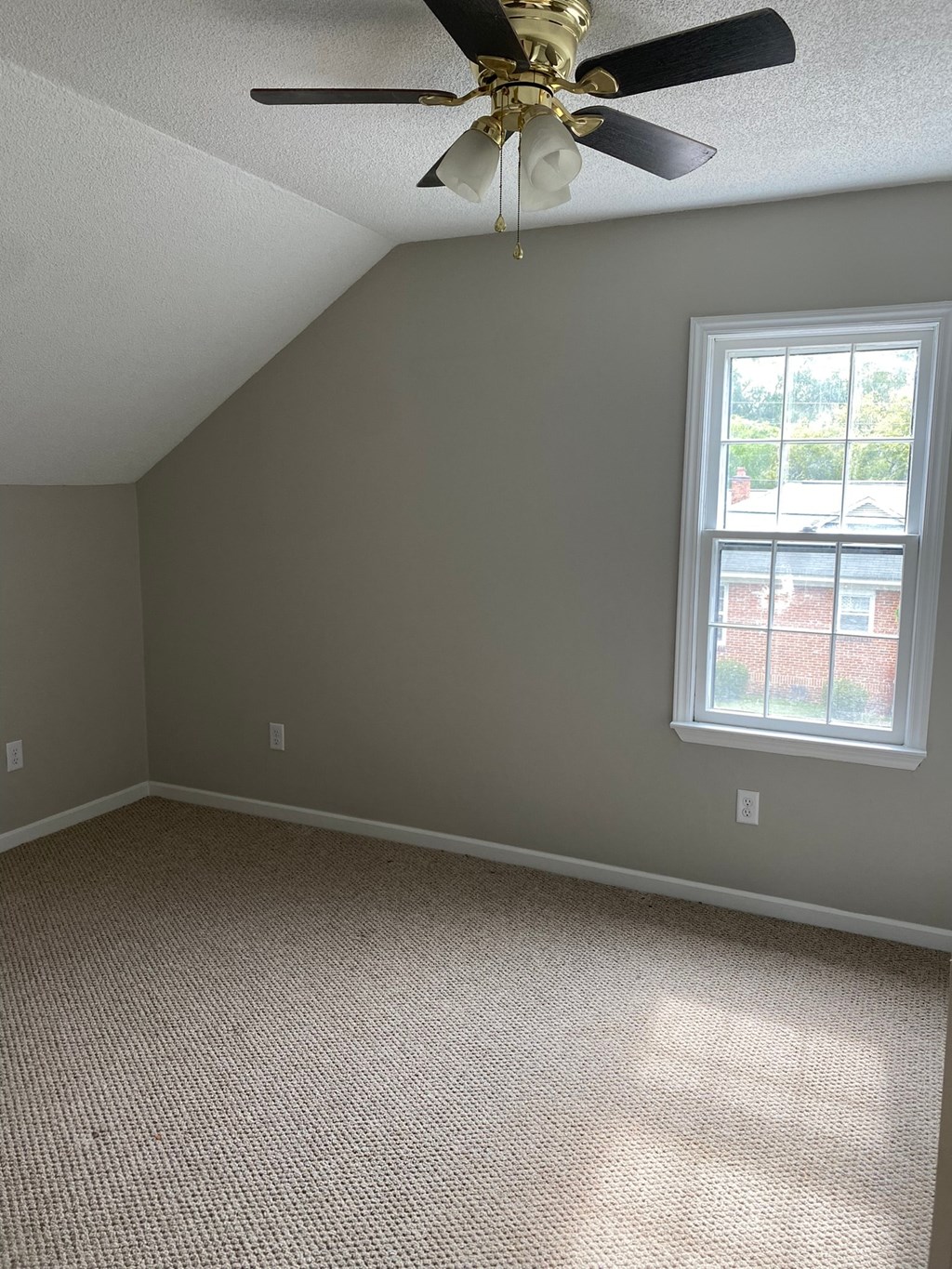 an empty room with a ceiling fan and a window