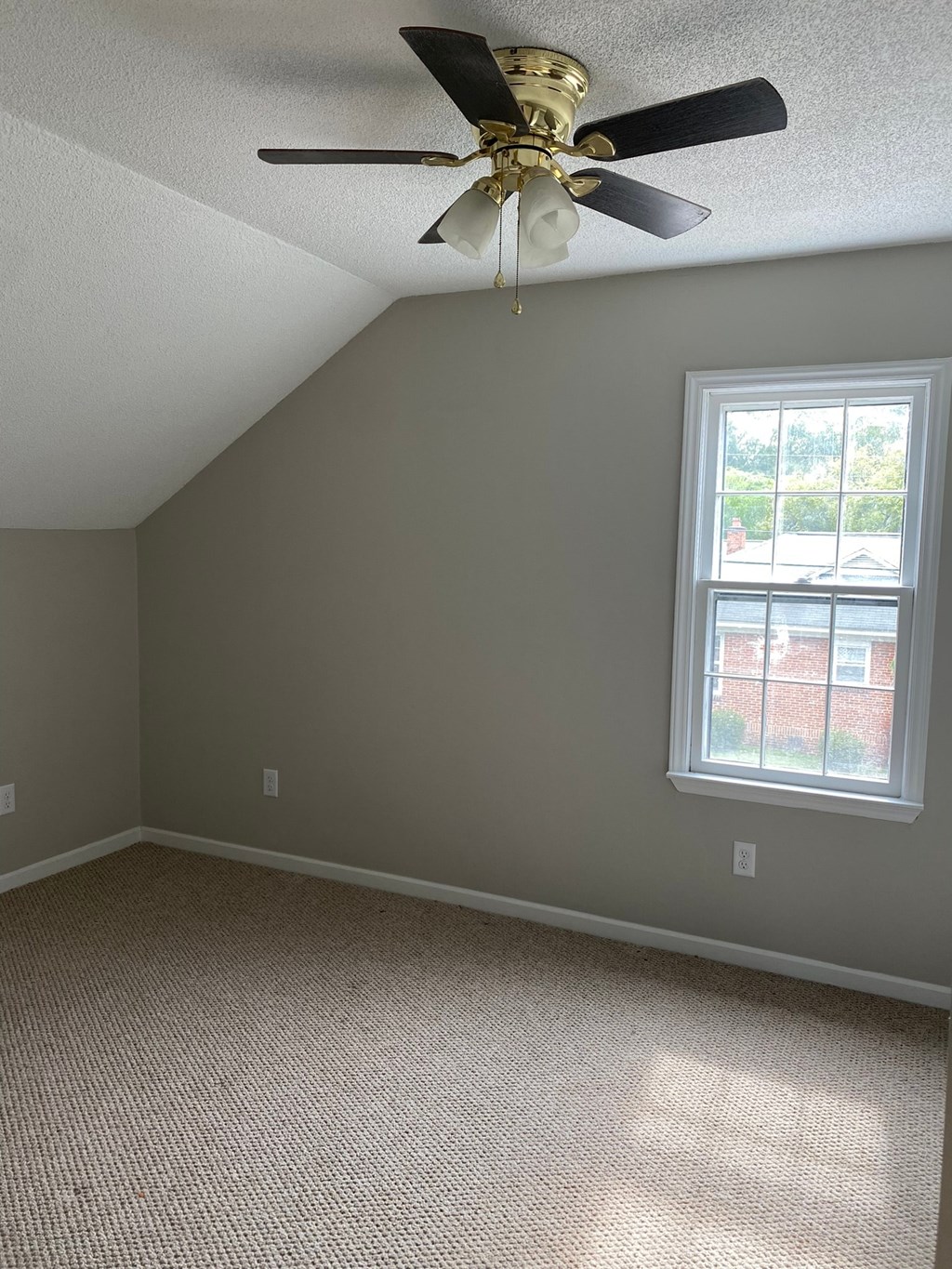 an empty room with a ceiling fan and a window