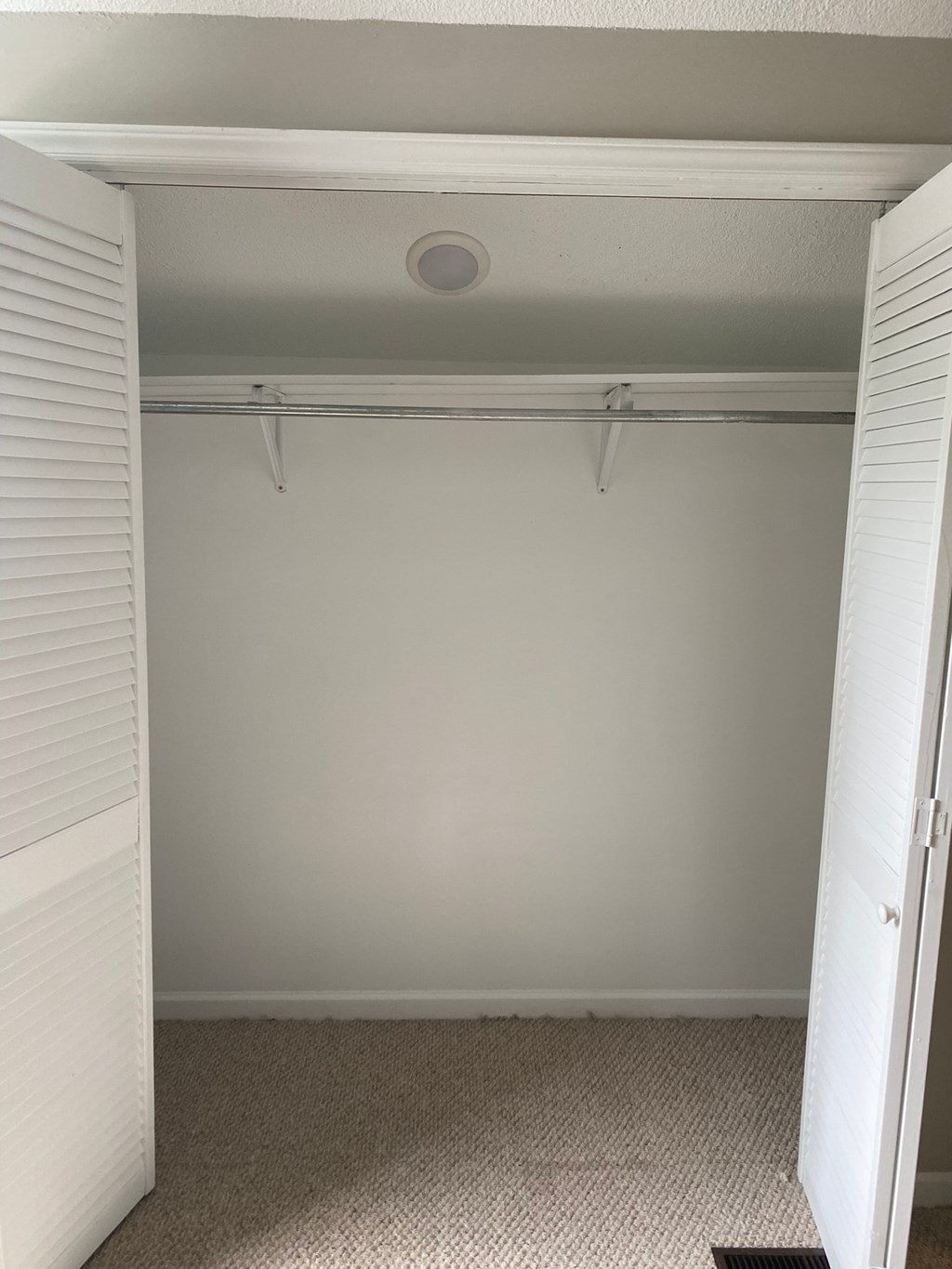 an empty closet in a room with white walls