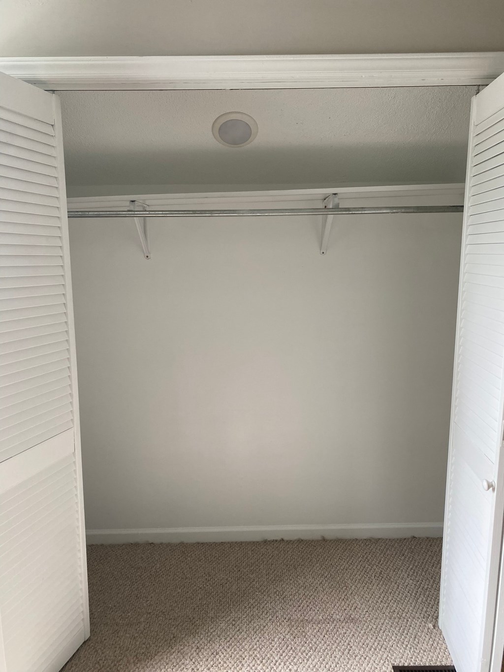 an empty closet in a room with a white wall