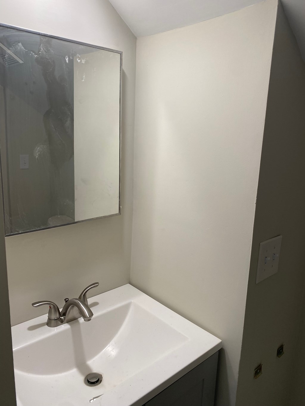 a small bathroom with a sink and a mirror