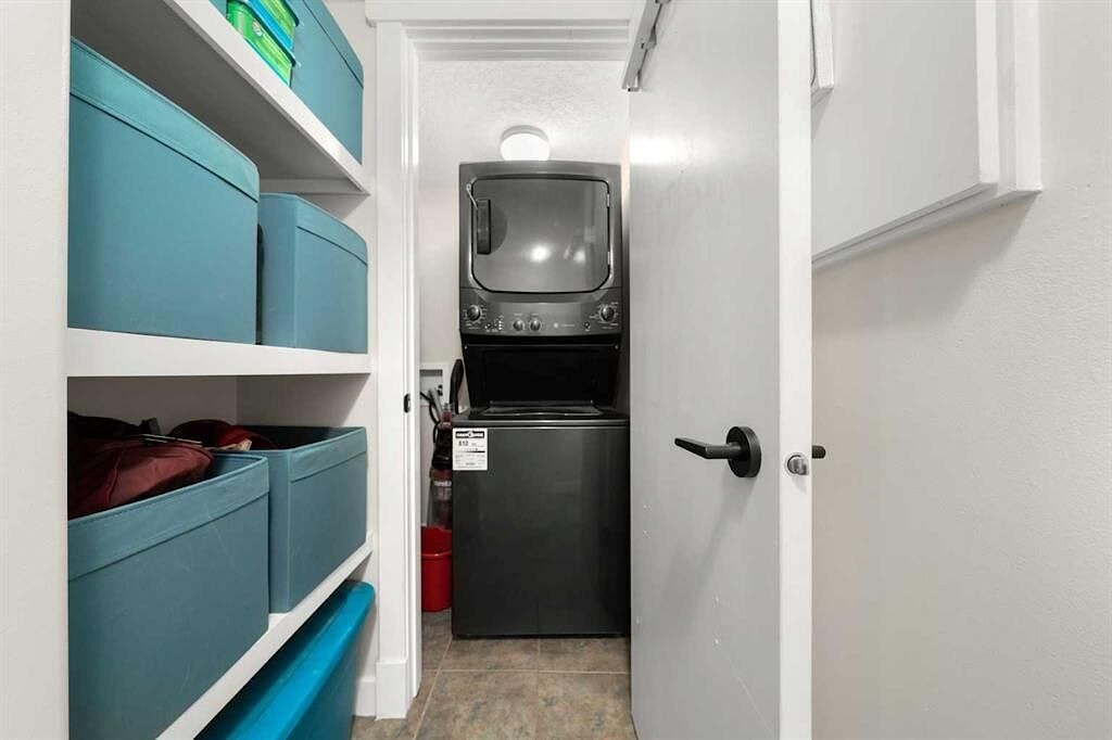 A small kitchen with a black fridge and a white door.