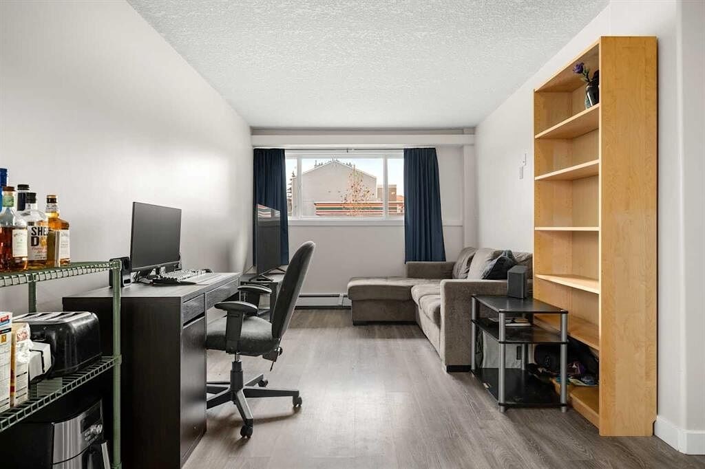 A room with a desk, a couch, and a chair.