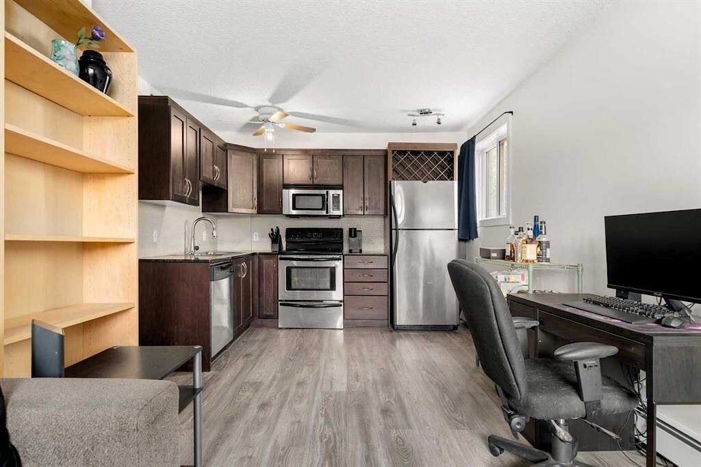 A kitchen with a desk and chair in front of it.