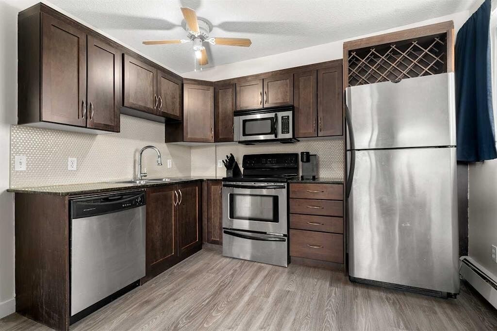 A kitchen with brown cabinets and stainless steel appliances.