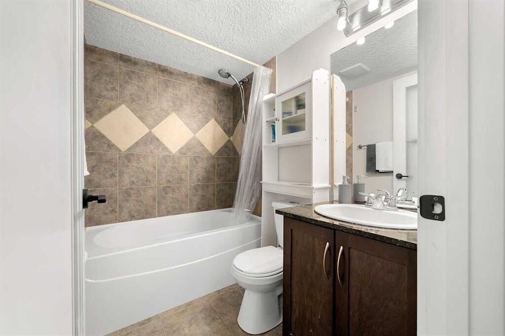 A bathroom with a white toilet, sink, and bathtub.