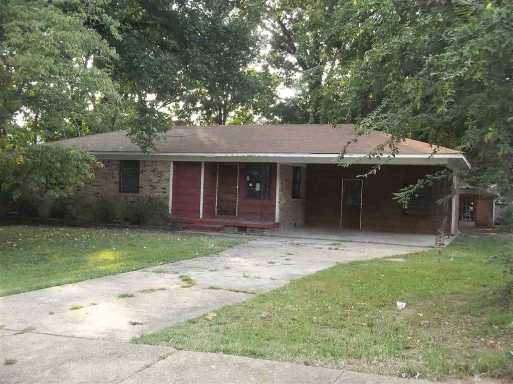 a small brick house with a sidewalk in front of it