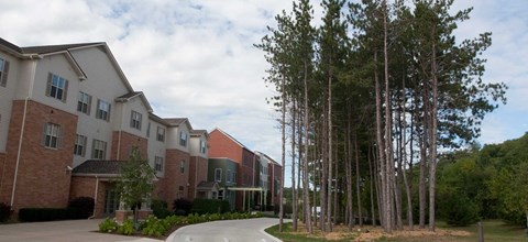 A row of apartment buildings are surrounded by trees.