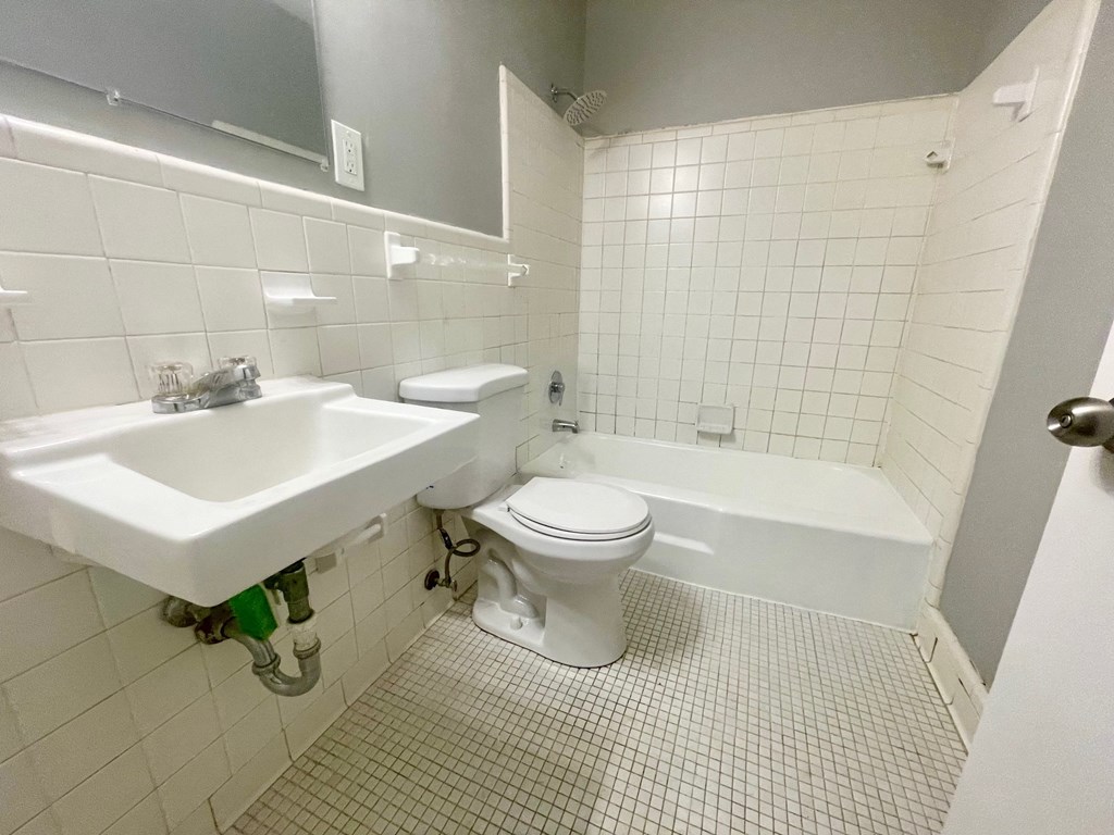 a bathroom with a toilet and a sink and a bath tub