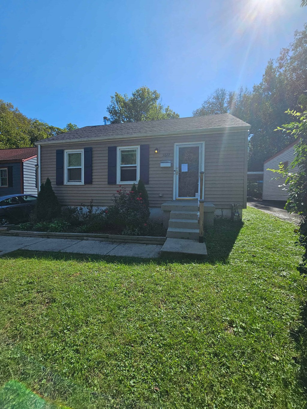 a small house with a front porch and a lawn