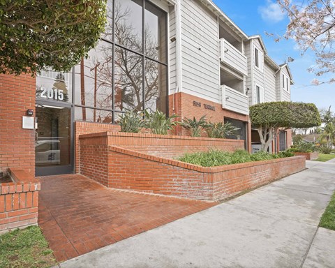 A modern building with a brick wall and glass windows.