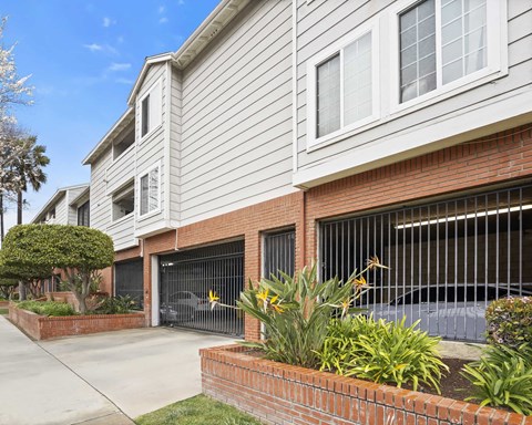A house with a grey siding and a brick wall.