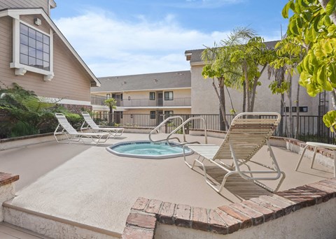 A pool with a chair and a building in the background.