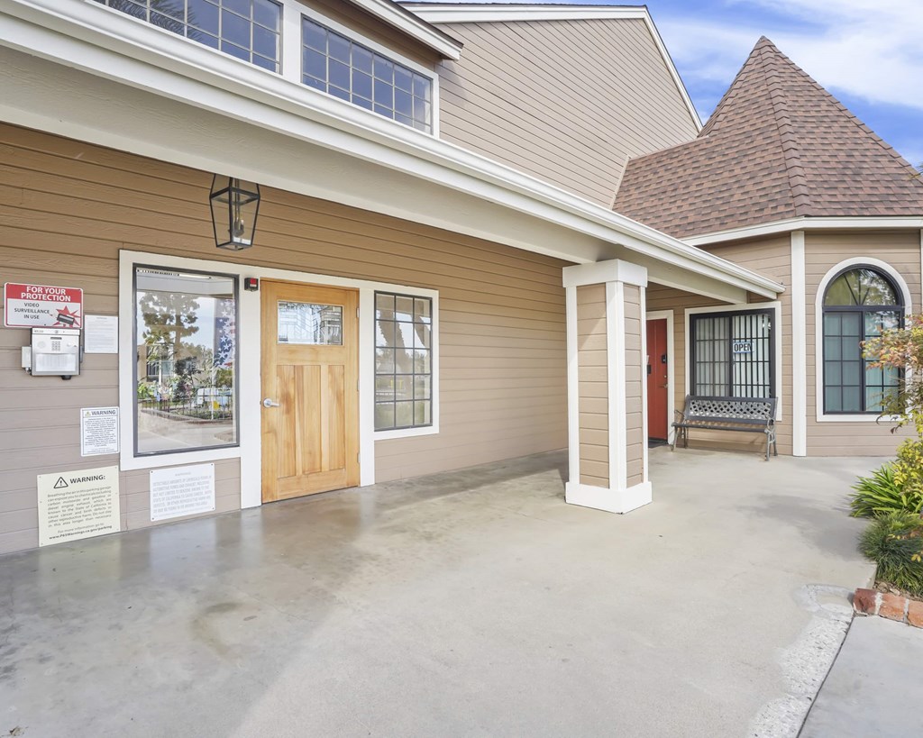A building with a brown and beige exterior has a sign that says "No Trespassing" on it.