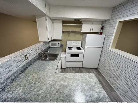 a kitchen with white appliances and a sink and a refrigerator
