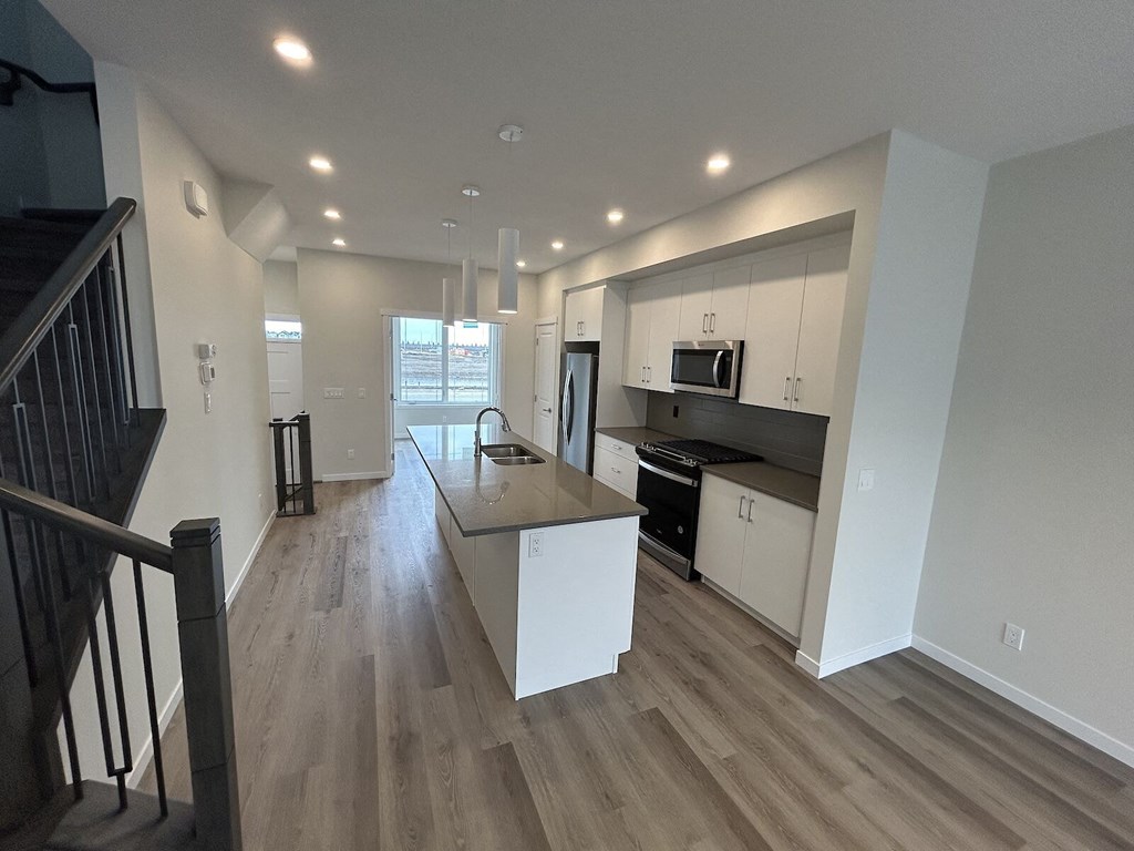 a renovated kitchen with white cabinets and a counter top