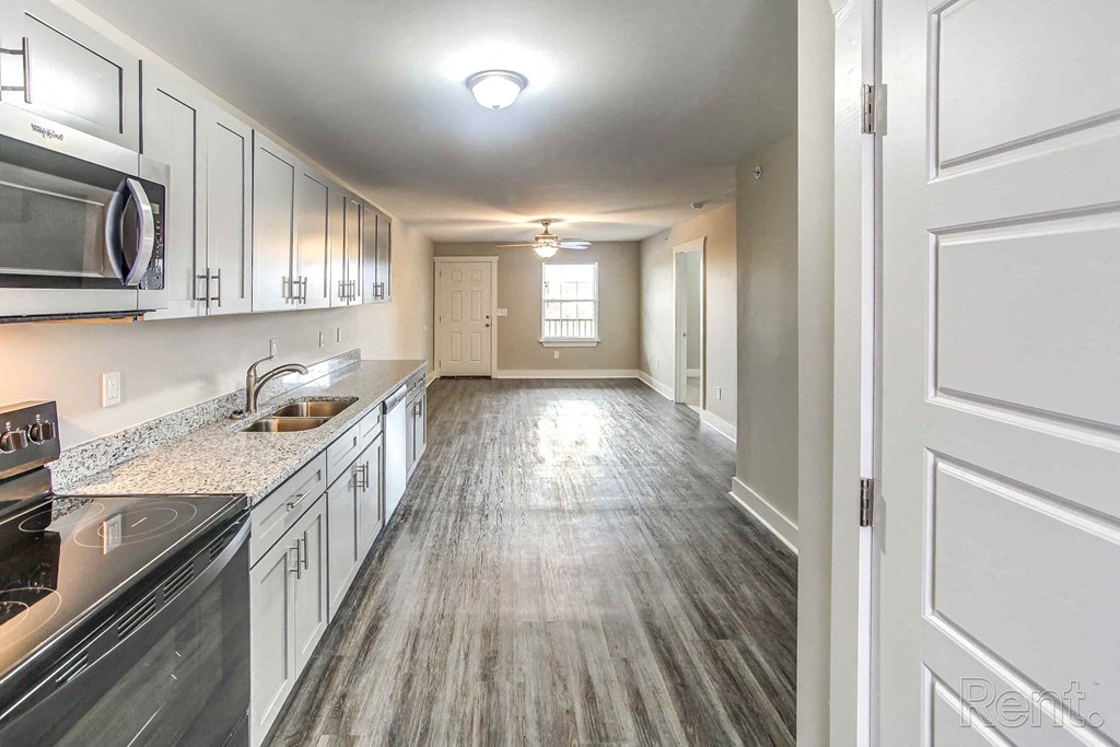 A kitchen with a black stove top oven and a white microwave.