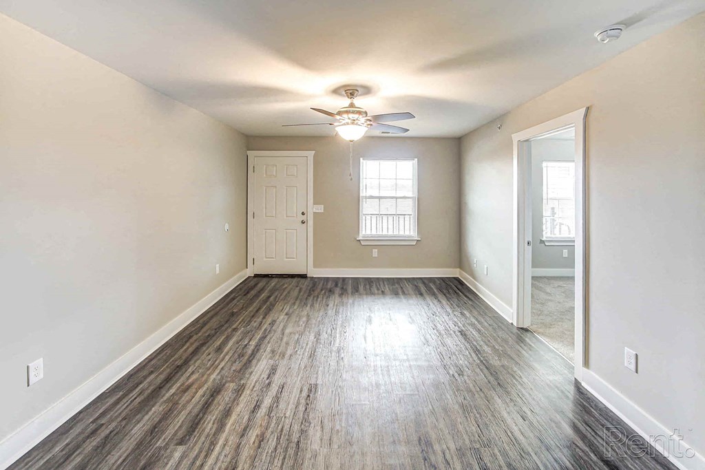 A room with a wooden floor and a ceiling fan.