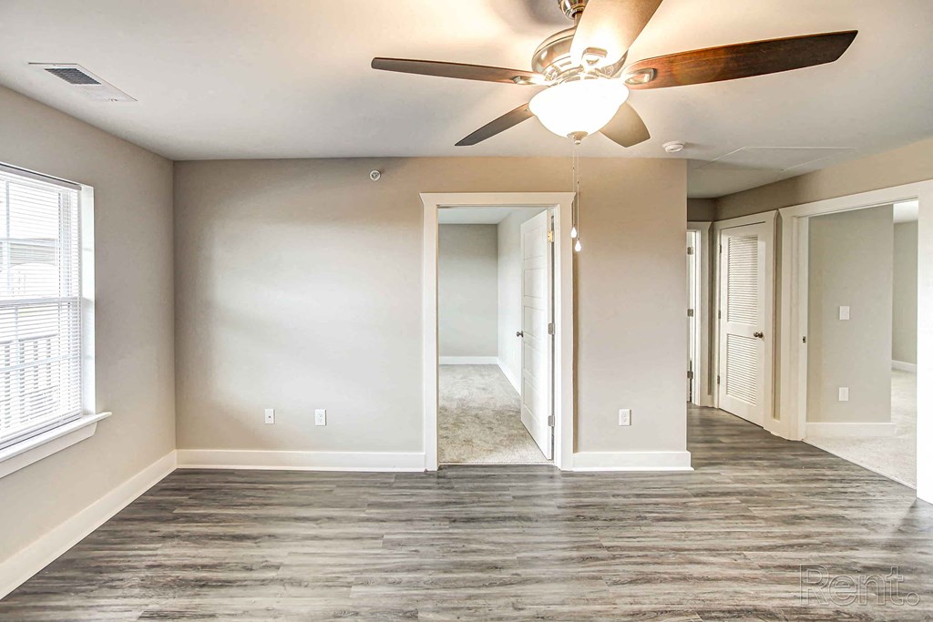 A room with a ceiling fan and a large mirror on the wall.