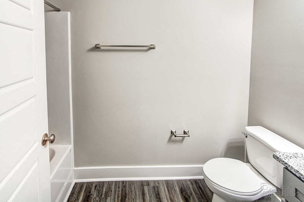 A white toilet sits in a bathroom next to a white door.