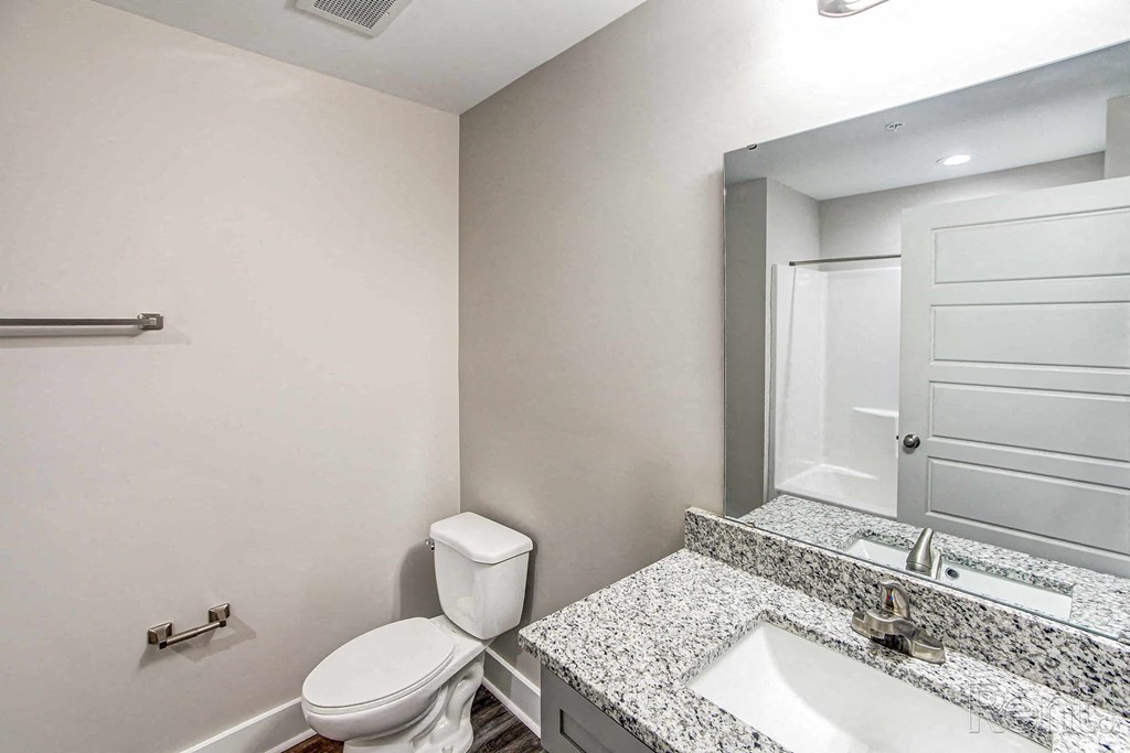 A white toilet sits next to a sink in a bathroom.