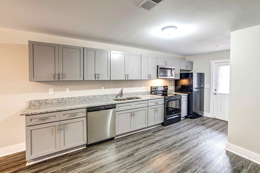 A kitchen with a granite countertop and stainless steel appliances.