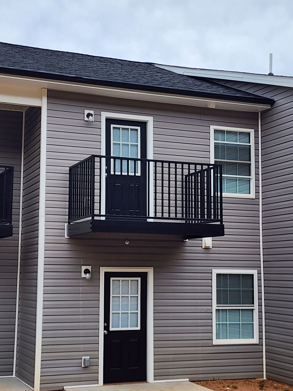 A two-story house with a balcony on the second floor.