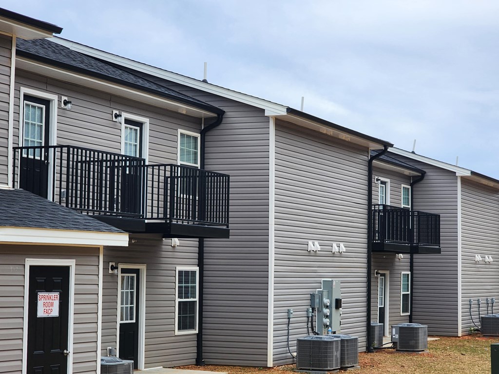 A row of houses with balconies and a sign on the door.