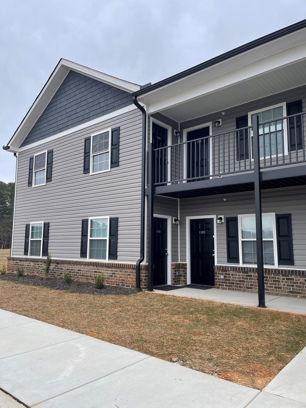 A grey house with a black door and windows.