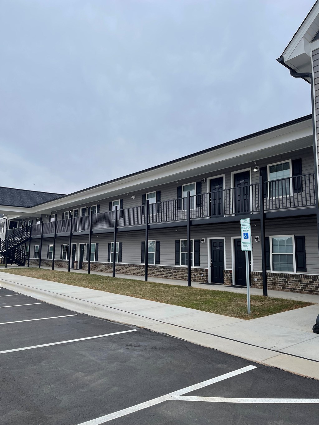 A parking lot in front of a building with a blue sign.