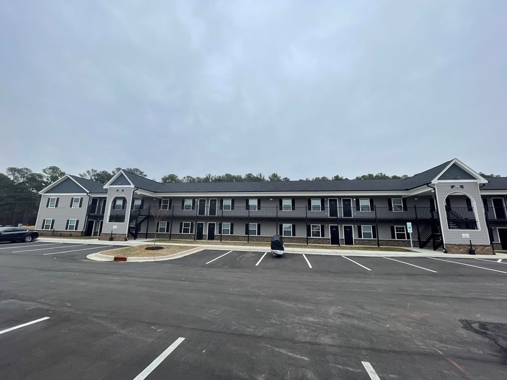 A large building with a parking lot in front.