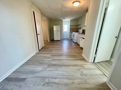 A long hallway with a kitchen at the end.