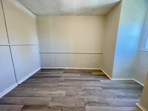 A room with wooden flooring and white walls.