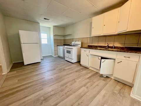 A kitchen with white appliances and cabinets.
