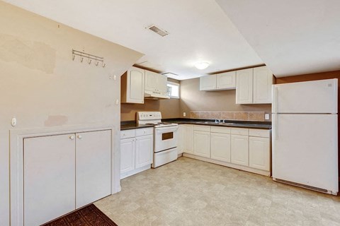 a kitchen with white cabinets and a white refrigerator