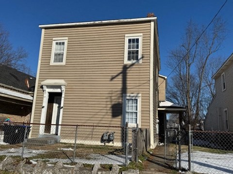 A two-story house with a brown siding and a white trim.