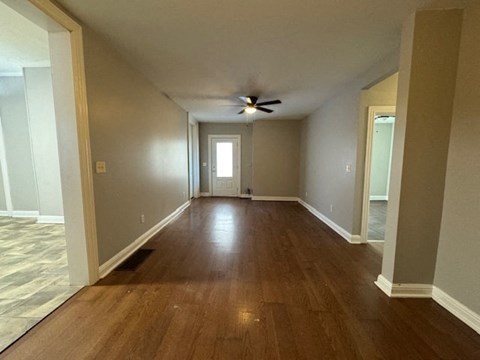 A room with wooden floors and a ceiling fan.