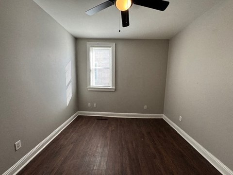 A room with a ceiling fan and a window.