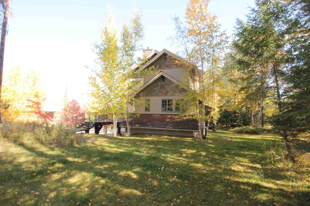 a small house in the woods with a bridge