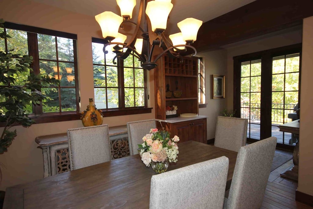 a dining room with a wooden table and chairs and a chandelier