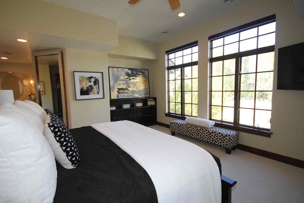 a bedroom with a large bed and windows