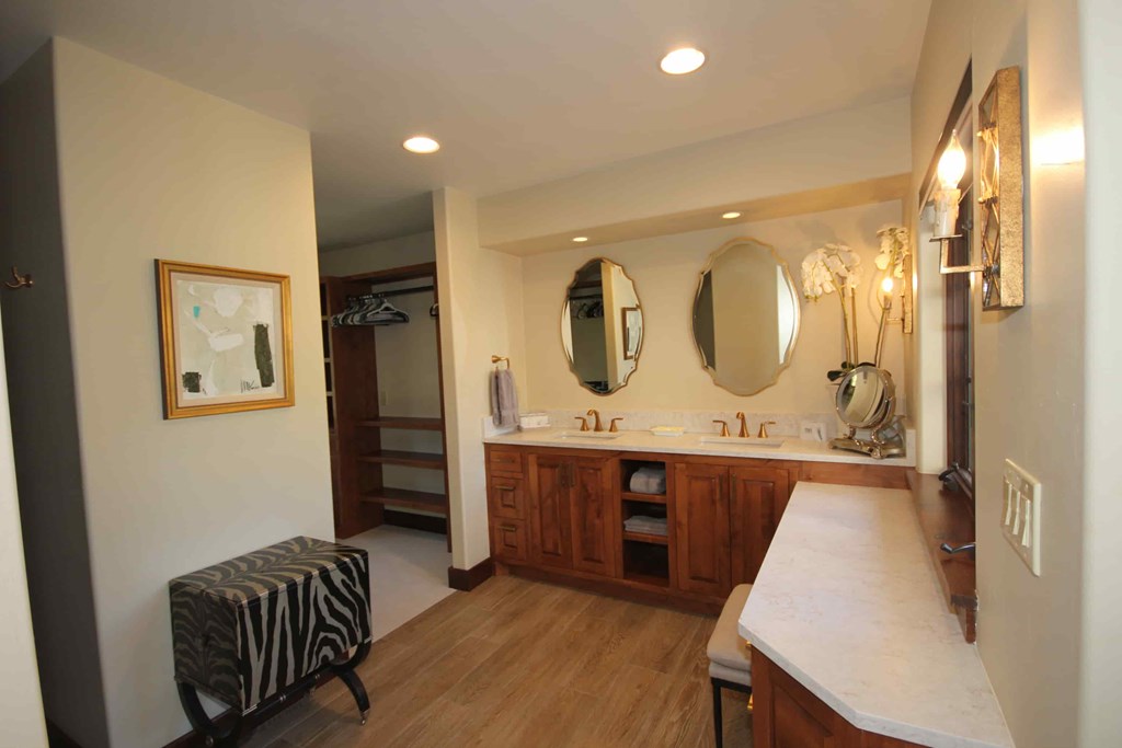 a large bathroom with a double vanity and a zebra stool