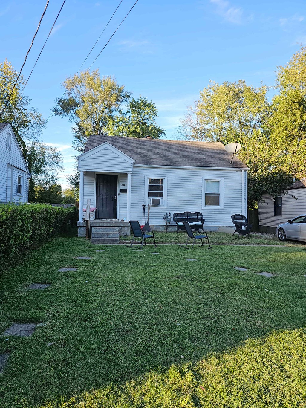 A white house with a black door and a small porch.
